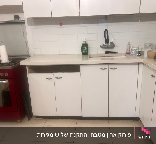 מטבח עם ארונות לבנים וכיור, תנור אדום